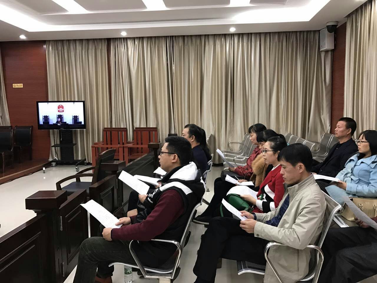 钦南区人大代表、政协委员及律师代表正在认真观摩庭审。
